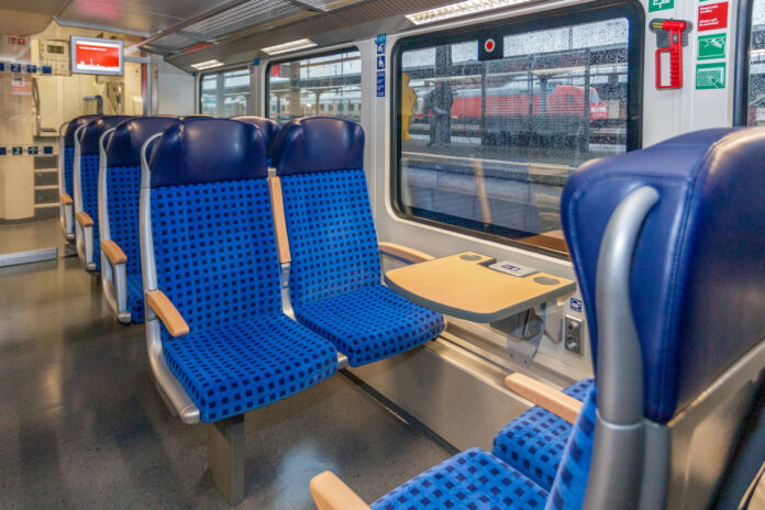 Blaue Sitzplätze im Innenraum eines Zuges der Deutschen Bahn