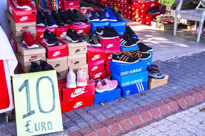 Verschiedene Schuhkartons gestapelt. Darunter sind Nike und Adidas Schuhe. Ein Schild zeigt, dass sie nur 10 Euro kosten.