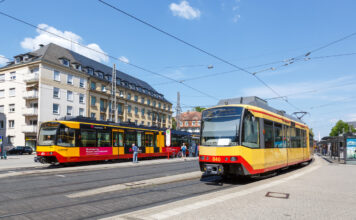 Zwei S-Bahnen fahren durch die Innenstadt. Sie transportieren die Fahrgäste durch die Metropole. Es handelt sich hierbei um Züge unterschiedlicher S-Bahn Linien im öffentlichen Personennahverkehr.