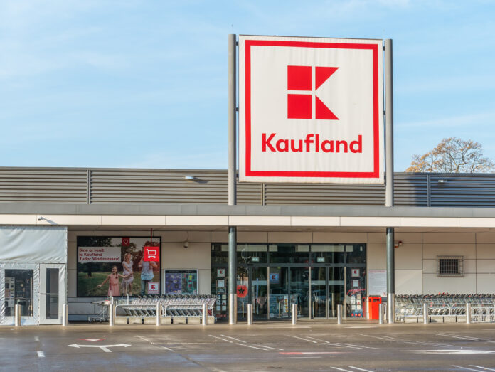 Eine geschlossene Kaufland-Filiale. Man erkennt es daran, dass die Lichter aus sind und keine Waren und Schilder vor dem Eingang stehen. Auch der Parkplatz ist leer. Auf diesem steht kein einziges Auto.