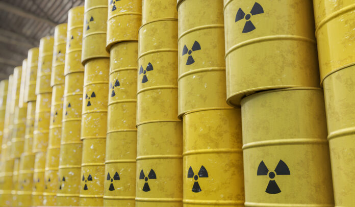 Zahlreiche gelbe Fässer mit Atommüll stehen in einer großen Halle über einander