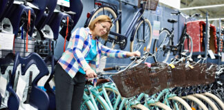 Eine Frau sucht sich in einem Fahrradladen ein neues Fahrrad aus.