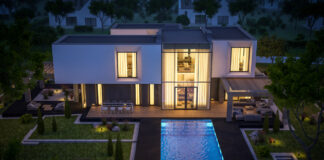 Eine große und imposante Villa ist in der Nacht beleuchtet. Ein großer Pool vor der Villa lädt zum Schwimmen ein. Es ist auf den ersten Blick zu erkennen, dass dieses Anwesen sehr kostspielig ist und nur für sehr reiche Menschen bezahlbar ist.