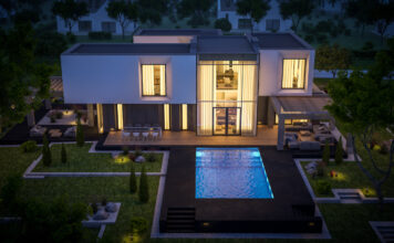 Eine große teure Villa und ein Pool davor bei Nacht