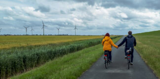 Pärchen Händchen haltend beim Fahrradfahren in Ostfriesland