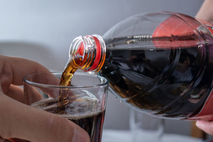 Coca-Cola wird in ein Glas gegoßen.