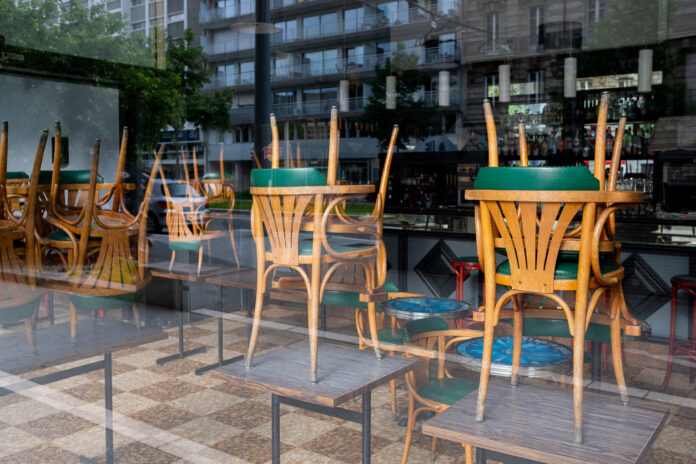 Ein geschlossenes Café mit einer Bartheke und umgedrehten Stühlen.