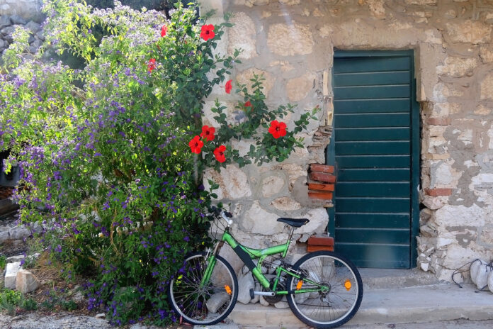 Ein Fahrrad lehnt an der Mauer im Garten.