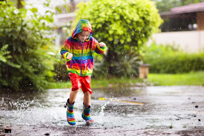Kind spielt bei Regen im Park