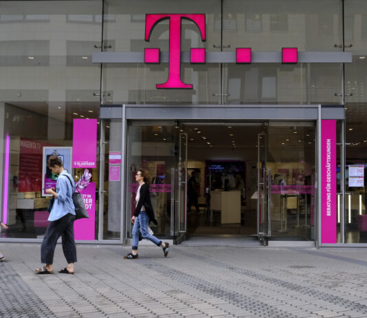 Eine geöffnete Telekom-Filiale in Deutschland, an der mehrere Menschen vorbeigehen. Zur Fußball-EM in Deutschland will der Konzern seinen Kunden ein besonderes Geschenk machen.