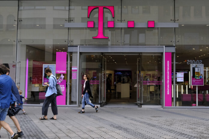 Eine geöffnete Telekom-Filiale in Deutschland, an der mehrere Menschen vorbeigehen.