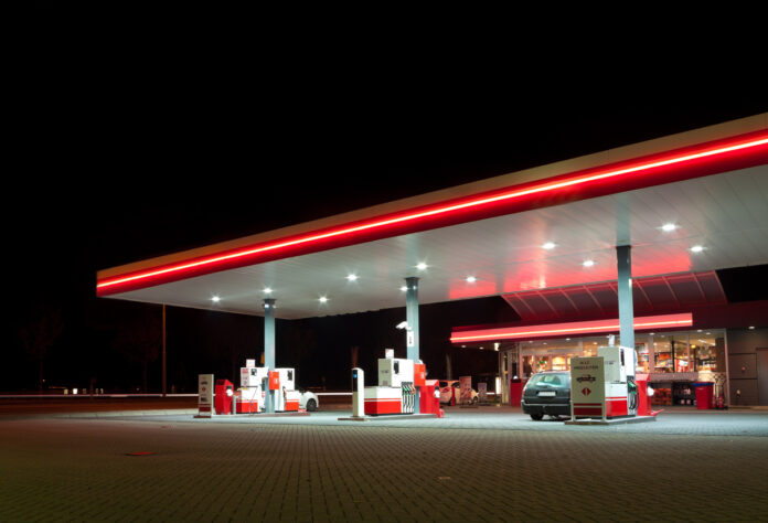 Eine abends beleuchtete Tankstelle.