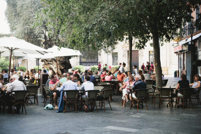 Menschen sitzen draußen vor einem Café.