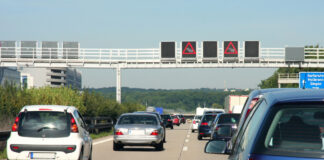 Mehrere Fahrzeuge fahren auf einer Autobahn, auf der eine Geschwindigkeitsbeschränkung gilt.
