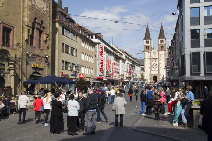 Eine Einkaufsstraße in Deutschland, Baden-Württemberg. Passanten und Bürger laufen durch die Straße, sie gehen shoppen und schauen in die verschiedenen Geschäfte und Familienbetriebe hinein. Immer mehr Läden gehen insolvent.