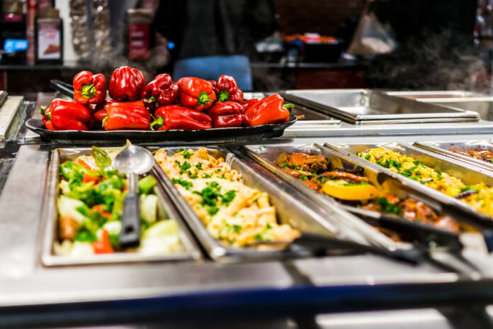 Die Auslage eines Bufetts in einem Restaurant oder in einer Kantine bestückt mit Lebensmitteln und Gemüse