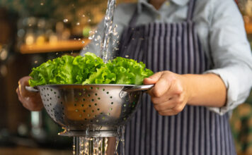 Eine Frau wäscht Salat.