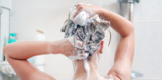 Frau unter der Dusche beim Haarewaschen.