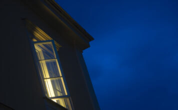 Ein Fenster steht offen in der Nacht und es dringt Licht nach außen