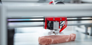 Ein 3D-Drucker druckt ein Stück Fleisch aus.