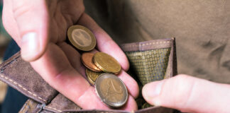 Eine Person zählt Münzen im Geldbeutel.
