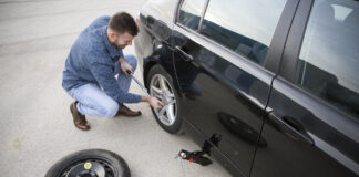 Ein Mann wechselt die Reifen an seinem Auto