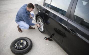 Ein Mann wechselt die Reifen an seinem Auto