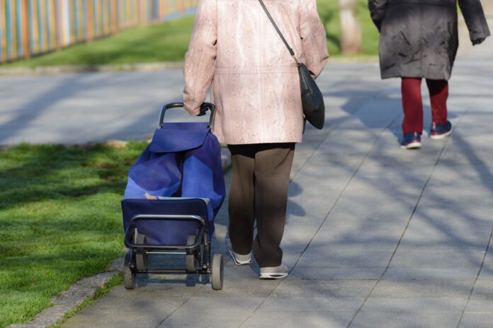 Eine Rentnerin sammelt Pfandlfaschen.