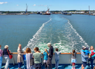 Kinder und Erwachsene sind alle auf einem Schiff und beobachten das Wasser während der Fahrt und die Wellen