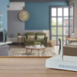 Ein weißer WLAN Router steht auf einer Oberfläche in einer modern eingerichteten Wohnung.