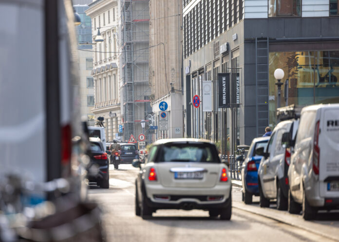 Viele Autos stehen auf einer stark befahrenen Straße in einer Großstadt.