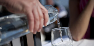 Hahnenwasser oder auch Leitungswasser wird in ein Glas gegossen.