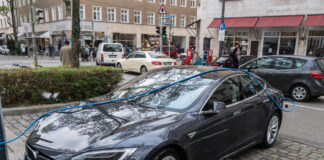 Ein Tesla oder ein Elektroauto steht auf einem Parkplatz in der Innenstadt