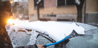 Ein Auto wird von Eis und Schnee entfernt.