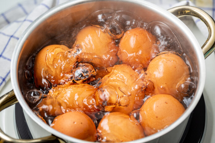 Eier in einem kleinen Topf mit kochendem Wasser.