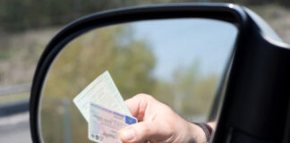 Ein Mann zeigt seinen Führerschein vor.