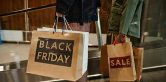 Zwei Personen halten Papiertüten mit Produkten vom Black Friday in der Hand