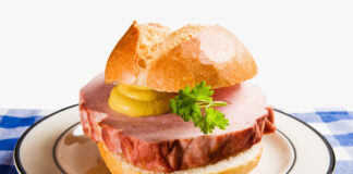 Ein Brötchen mit einer dicken Scheibe Leberkäse mit Senf und Petersilie liegt auf einem Teller. Nur noch 20 Prozent der Deutschen essen jeden Tag Fleisch.