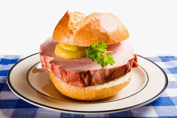 Ein Brötchen mit einer dicken Scheibe Leberkäse mit Senf und Petersilie liegt auf einem Teller. Nur noch 20 Prozent der Deutschen essen jeden Tag Fleisch.