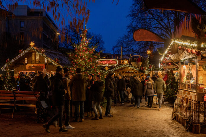 Ein Weihnachtsmarkt mit vielen Menschen und Ständen.