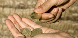 Eine Person zählt Münzen in der Hand