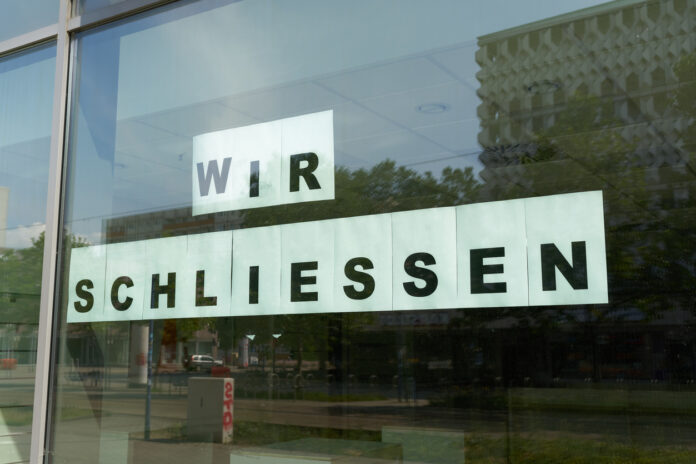 Ein Laden hat ins Schaufenster die Nachricht "Wir schließen" in Großbuchstaben geklebt. Das Geschäft, das ein wichtiger Ort für die Bürger war, macht wohl bald für immer zu.