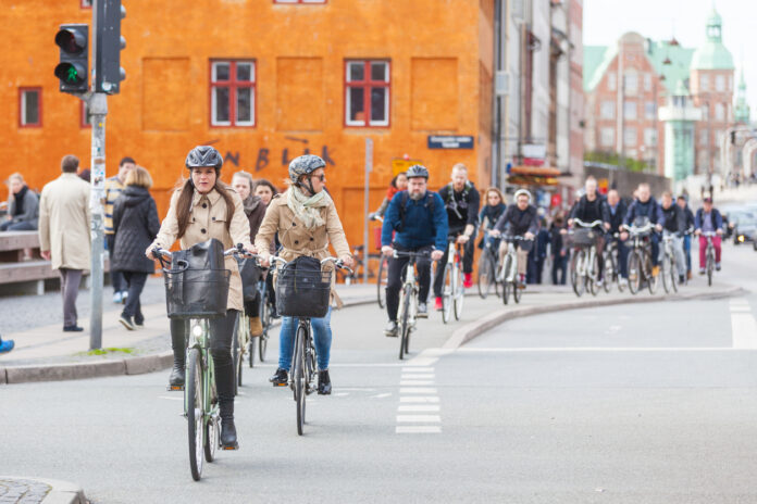 Viele Menschen fahren mit ihren Fahrrädern über die Straße im Straßenverkehr