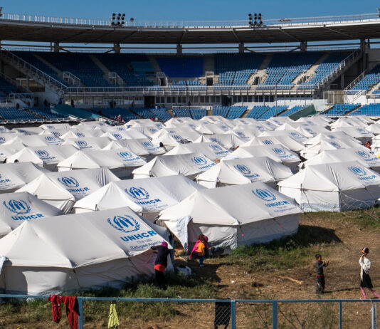 Eine große Flüchtlingsunterkunft mit vielen Zelten und Kindern, die dort spielen