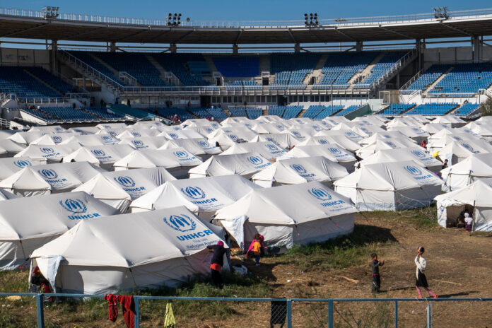 Eine große Flüchtlingsunterkunft mit vielen Zelten und Kindern die dort spielen