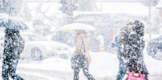 Menschen laufen im Schneegestöber.