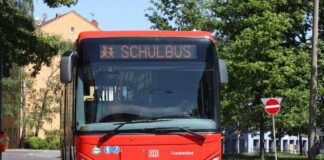 Ein roter großer Schulbus an einer Haltestelle