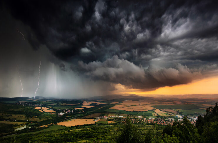Ein schweres Gewitter fegt über eine Landschaft. Das Gewitter bringt Blitz, Donner, Sturm und Hagel mit sich. Am Himmel ziehen dunkle, bedrohliche Wolken auf.