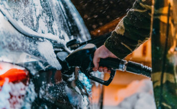 Ein Mann tankt im Winter an einer Tankstelle sein Auto.