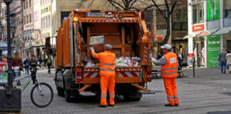 Zwei Mitarbeiter der städtischen Müllabfuhr entsorgen gerade den Müll in der Innenstadt von Karlsruhe